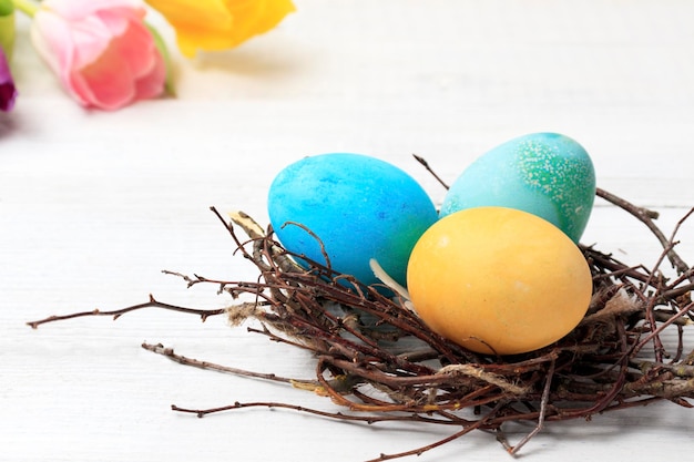 Easter Easter eggs and spring flowers tulips on wooden planks