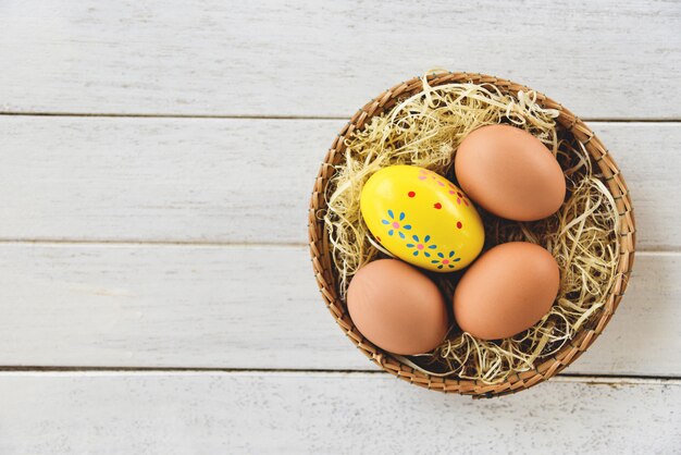 Easter egg and chicken eggs in basket nest 