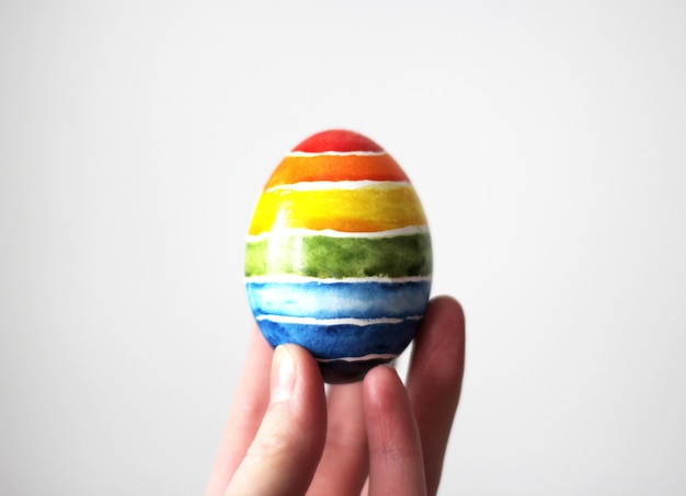 Easter egg in hand on white background