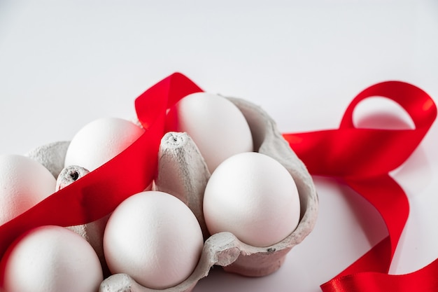 Easter eggs in a cardboard box with a red festive ribbon  