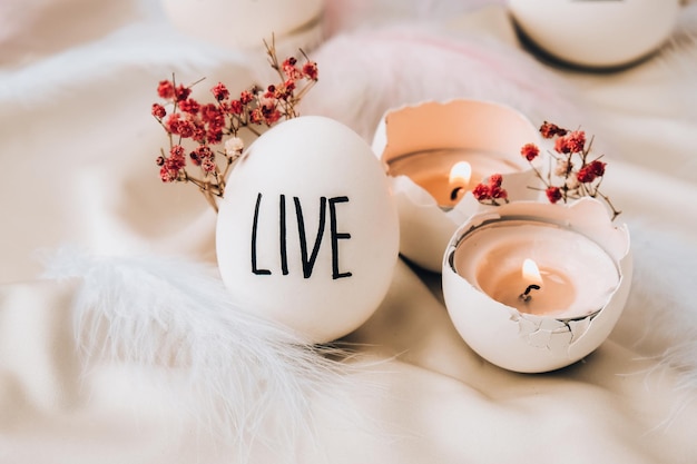 Easter eggs Composition. Easter message, Words drawn with pen. High Angle View Of Shells On Table. Live. Candle in egg shell. Candle light