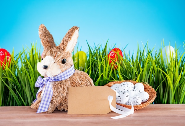 Easter eggs and cute bunny on wood table with green grass. Festive decoration