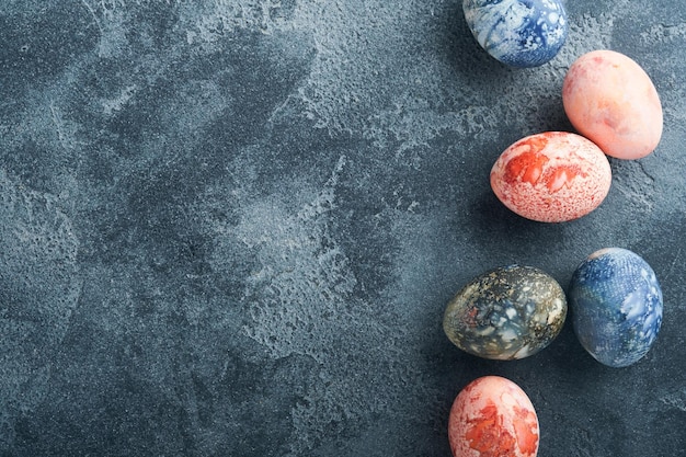 Easter eggs Dyed Easter eggs with marble stone effect ref and blue color in rustic style on dark stone background Easter background Top view