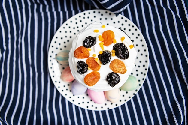 Easter eggs and Easter cake are on a plate lying on a striped blue apron Easter religious holiday concept