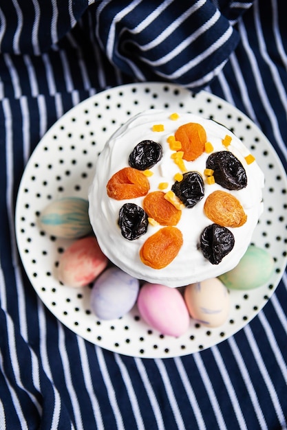 Easter eggs and Easter cake lie on a plate lying on a striped blue apron Easter religious holiday concept