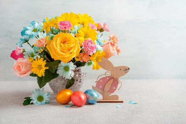 Easter eggs, easter rabbit and spring flowers, space for text. Happy Easter. Congratulatory easter background.