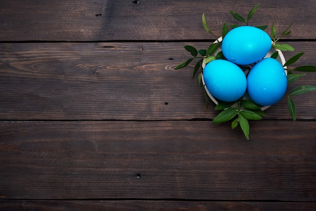 Easter eggs painted by hand colored on a dark wooden table