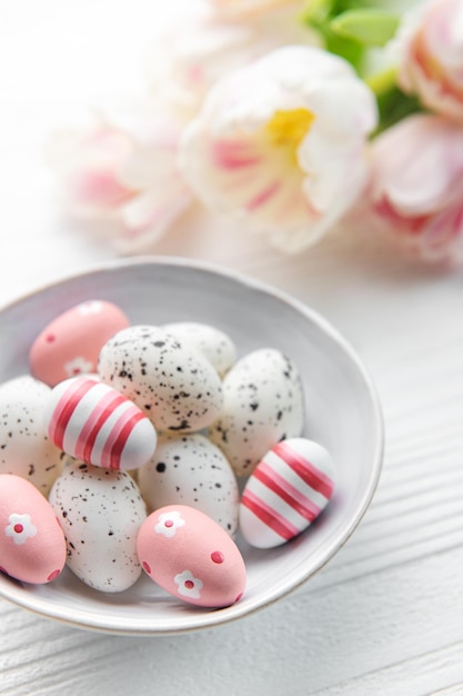 Easter eggs painted pastel colors on a white wooden background