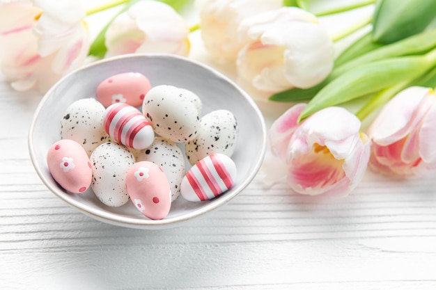 Easter eggs painted pastel colors on a white wooden background