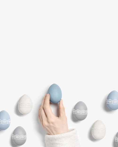 Easter eggs pastel colors green blue gray beige on white background Woman hand hold dyed chicken