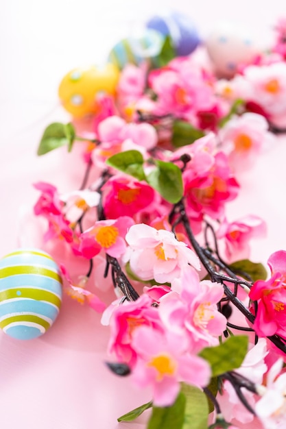 Easter eggs and pink flowers on a pink backgorund.