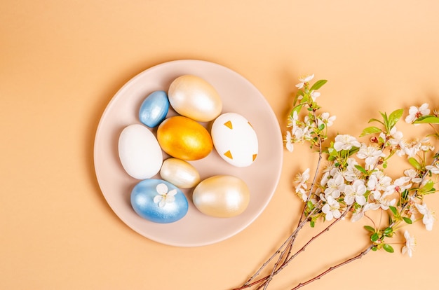 Easter eggs on a plate on a beige surface with copy space