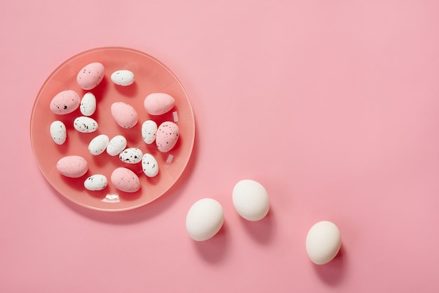 Easter eggs on plate on pink background.