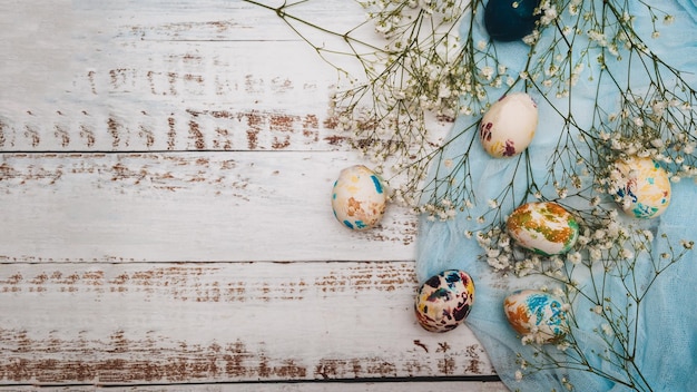 Easter eggs small white flowers and decorations on a light background Happy easter flat lay concept A place for your text