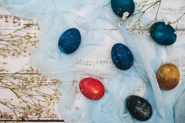 Easter eggs small white flowers and decorations on a light background Happy easter flat lay concept