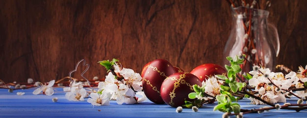 Easter eggs and spring white flowers on Easter blue background with copy space