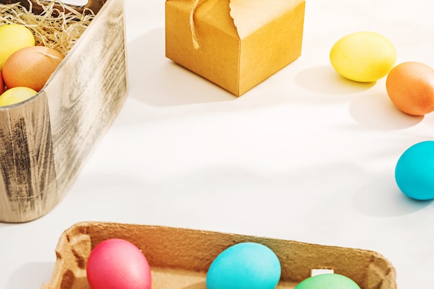 Easter eggs in the sunlight on the white table near the window. Bright spring Easter background