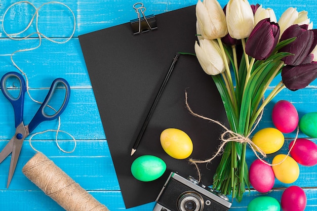 Easter eggs and tulips on blue rustic wooden planks