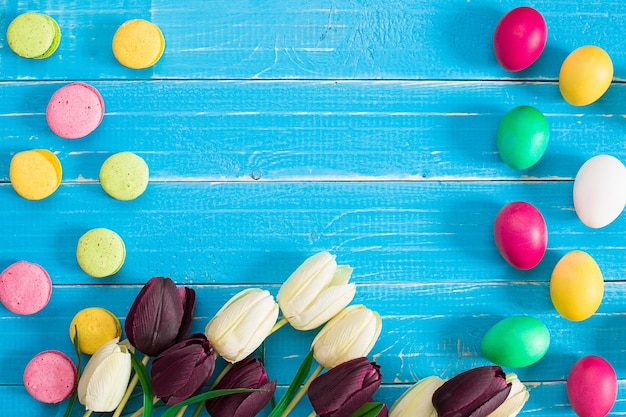 Easter eggs and tulips on blue wooden planks