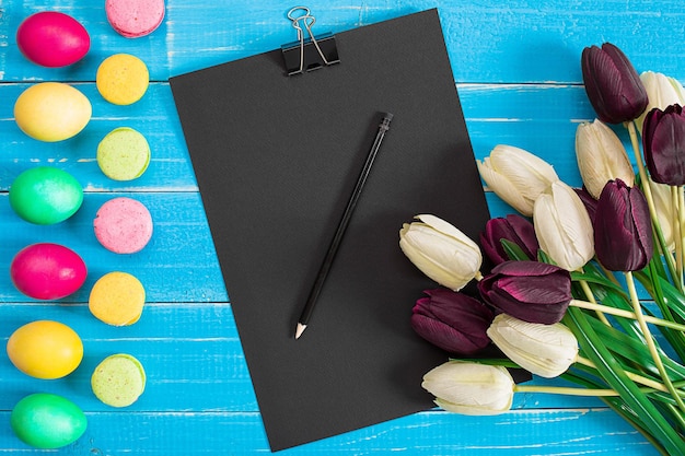 Easter eggs and tulips on blue wooden planks