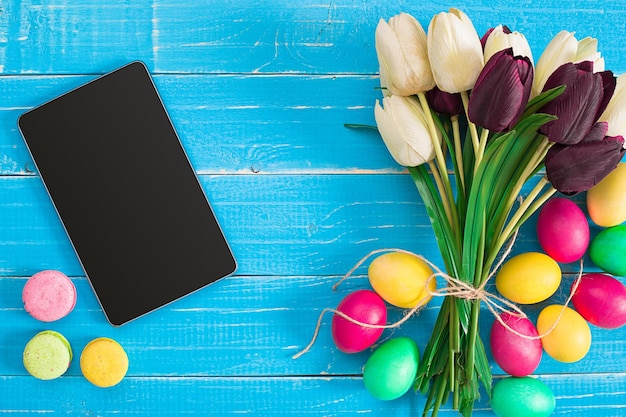 Easter eggs and tulips on blue wooden planks