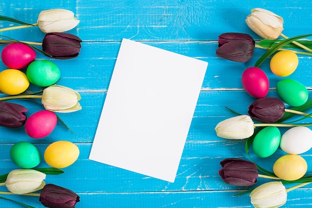 Easter eggs and tulips on blue wooden planks