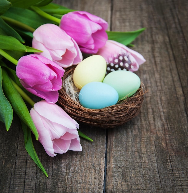 Easter eggs and tulips on a old wooden background