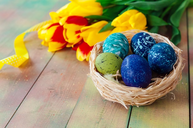 Easter eggs and tulips on wooden planks