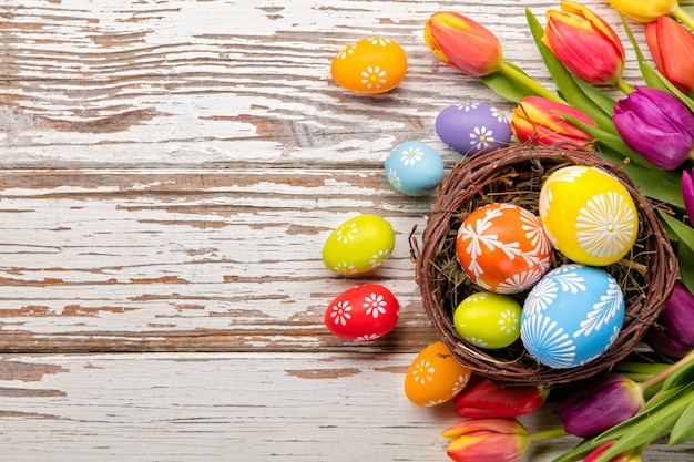 Easter eggs and tulips on wooden planks