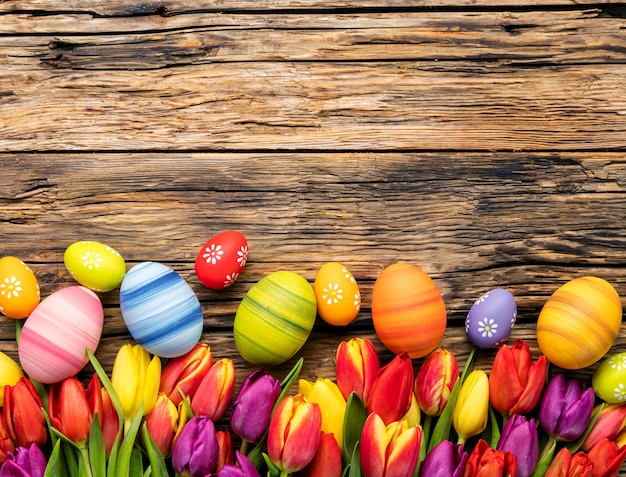 Easter eggs and tulips on wooden planks