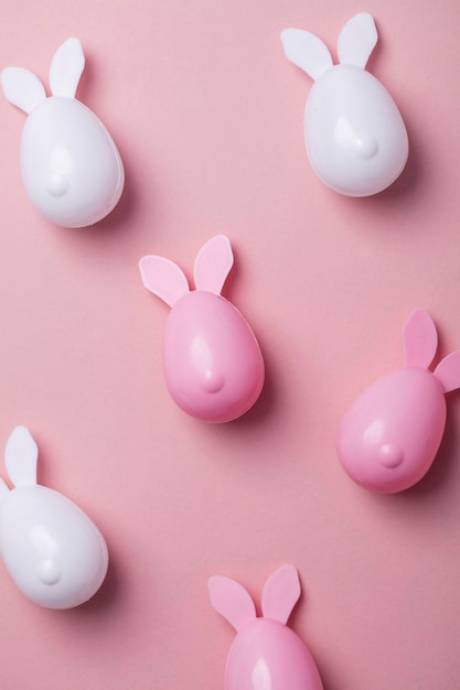 Easter eggs with bunny ears on a pastel pink background