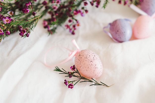 Easter eggs with flowers on white linen fabric Spring and Easter concept