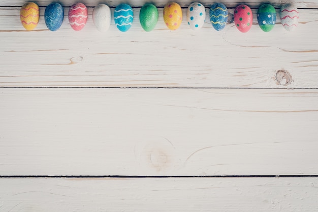 Easter eggs on wooden background. Pastel colorful easter eggs and hand paint on wooden background. 