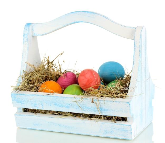 Easter eggs in wooden basket isolated on white