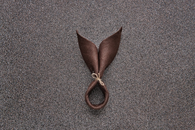 Easter gift concept- wrapped table-napkin in shape of bunny on dark stone