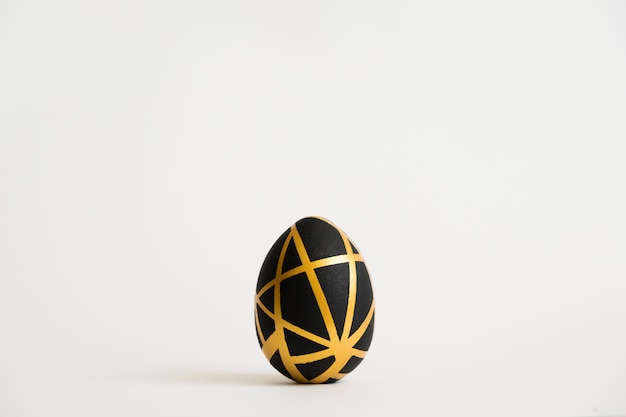 Easter golden egg with geometric black pattern isolated on white background