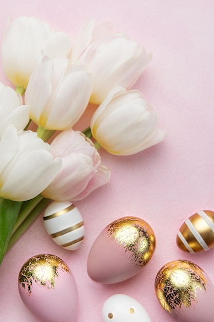 Easter golden eggs and pink tulips on pink background