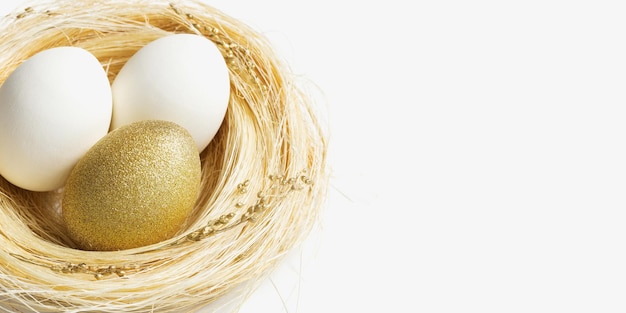 Easter golden and white eggs in straw nest on white background Trendy bright egg for spring