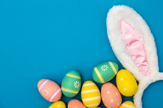 Easter holiday background with bunny ears and easter eggs on a blue background