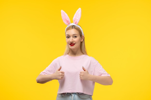 Easter lovely blonde adorable girl with pink bunny ears and red lipstick smiling with good gesture