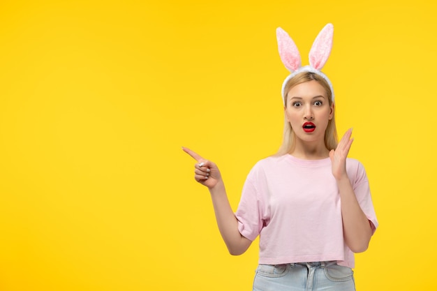 Easter lovely blonde adorable girl with pink bunny ears and red lipstick surprised with open mouth