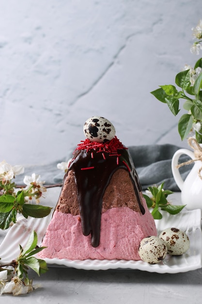 Easter Orthodox Curd dessert with cherries and chocolate decorated with quail egg on gray background