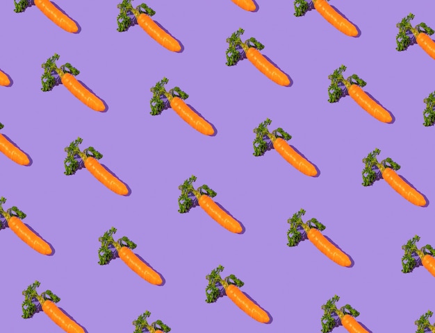 Photo easter pattern made with carrots on purple background creative minimal holiday concept