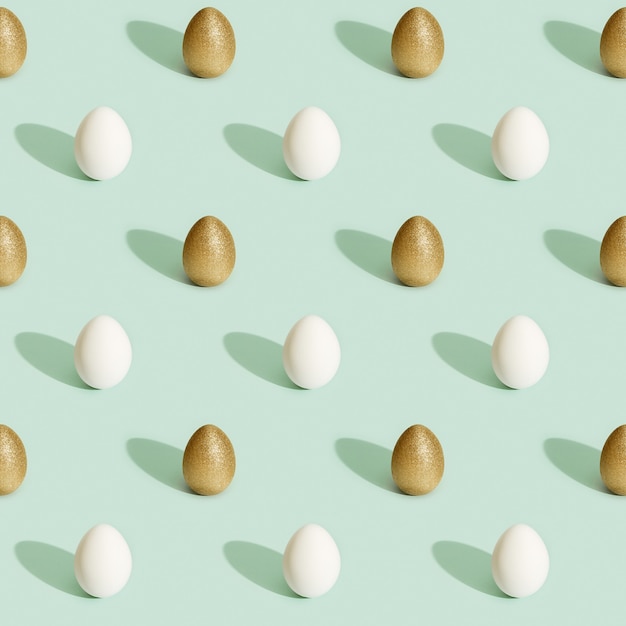 Easter pattern with bright eggs, shiny golden colored and white eggs on green paper