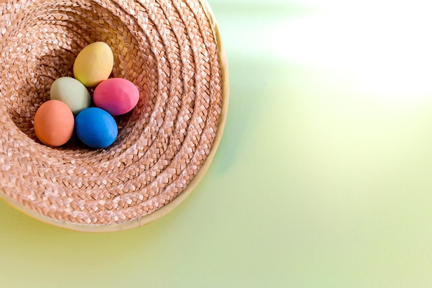 Easter picture with colorful eggs in a straw hat in country style