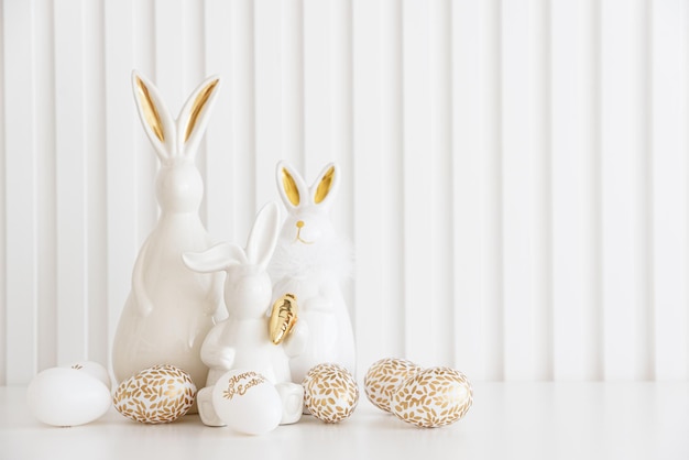 Easter rabbits figurines and eggs on white background