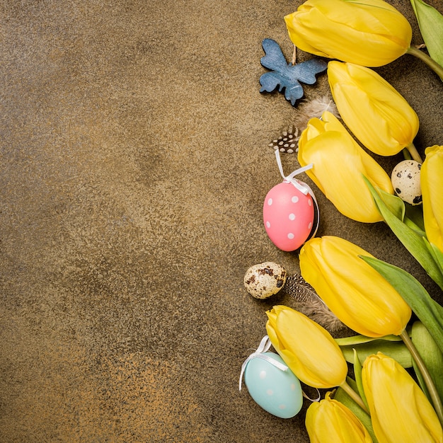 Easter surface with yellow tulips. Greeting card, copy space, flat lay, top view