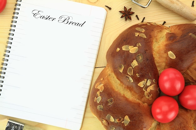 Easter sweet bread with red eggs and recipe book on the table