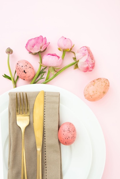 Easter table setting Easter eggs and flowers decoration napkin and golden cutlery