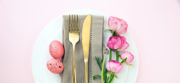 Easter table setting Easter eggs and flowers decoration napkin and golden cutlery